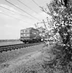 151011 Afbeelding van een voorbijsnellende electrische locomotief uit de serie 1300 van de N.S. in een landschap met ...